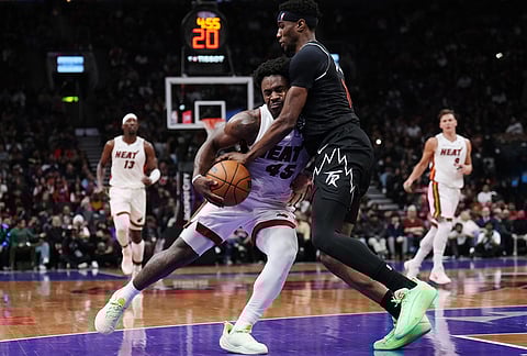 Miami Heat's Davion Mitchell (45) drives at Toronto Raptors' Ja'kobe Walter (14) during the second half of an NBA basketball game in Toronto.