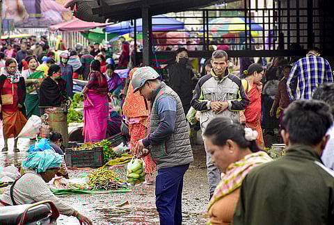People buy essential items at a market after curfew restrictions were relaxed for a few hours, in the wake of protests across the state against the Bishnupur bomb attack that killed two children, at Khwairamband Keithel Ima Market, in Imphal, Manipur.