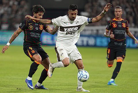 Ignacio Vazquez of Argentina's Platense, center, protects the ball from Yuri Alberto of Brazil's Corinthians during a Copa Libertadores Group E soccer match in Buenos Aires, Argentina.