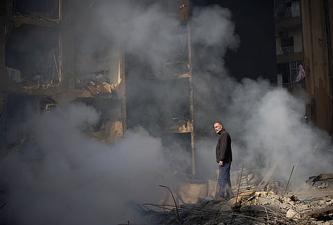 A man stands next to an apartment building destroyed in an Israeli airstrike a day earlier in Beirut, Lebanon, Thursday, April 9, 2026. 