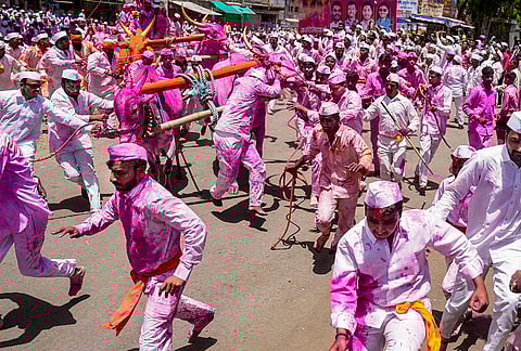 People attempt to control bulls that run loose after the chariot broke during the agrarian folk festival 'Bagad Yatra', in Surur, Satara district, Maharashtra.