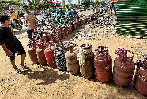 People wait with empty LPG cylinders to avail the refilled ones amid the ongoing supply crunch, in Patna, Bihar.