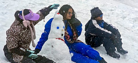 Tourists make a snowman at a snow-covered area, in Koksar area of Lahaul and Spiti district. 