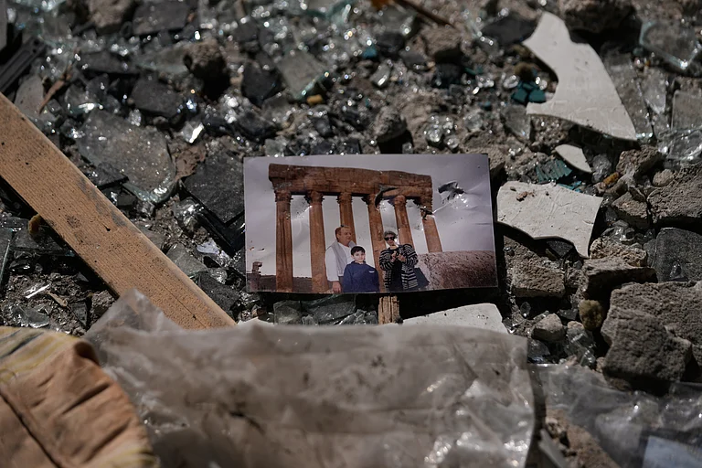 A family picture sits in the rubble at the site of a destroyed building that was hit a day ahead in an Israeli airstrike in central Beirut, Lebanon - Hussein Malla