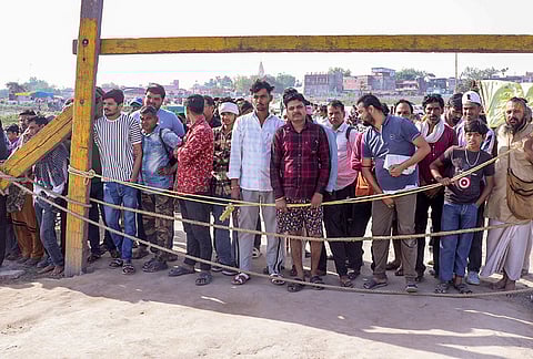 People gather during a search operation in the Yamuna river after a boat carrying pilgrims capsized on Friday, near Kesi Ghat, in Mathura district. At least ten people were killed and several others remain injured or missing. 