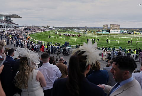 Crowds watch the racing on Ladies Day, the second day of the Grand National Horse Racing festival, at Aintree racecourse, near Liverpool, England.