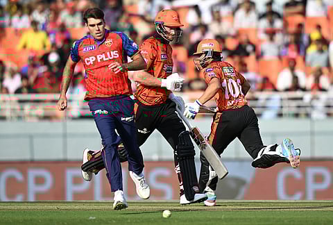 Punjab Kings' Xavier Bartlett, left, runs to field the ball as Sunrisers Hyderabad's Heinrich Klaasen, center, and batting partner Aniket Verma run between the wickets during the Indian Premier League cricket match between Punjab Kings and Sunrisers Hyderabad in New Chandigarh.