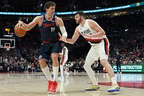 Los Angeles Clippers center Brook Lopez (11) looks to get past Portland Trail Blazers center Donovan Clingan (23) during the second half of an NBA basketball game in Portland, Ore.