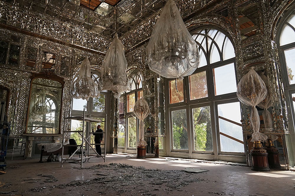 Broken glass lies on the floor beneath chandeliers covered in protective plastic in a room damaged, according to Iranian authorities, by a nearby airstrike during U.S.-Israeli strikes in early March at the Golestan Palace, a UNESCO World Heritage site, in Tehran, Iran. - Photo: AP/Francisco Seco