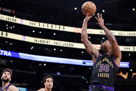 Los Angeles Lakers guard Marcus Smart (36) shoots as forward Maxi Kleber, back left, and Phoenix Suns forward Oso Ighodaro, back second from left, watch during the second half of an NBA basketball game in Los Angeles.