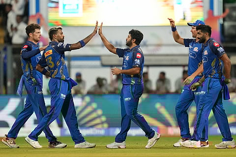 Mumbai Indians' Shardul Thakur and others celebrate dismissal of Royal Challengers Bengaluru's Phil Salt during the Indian Premier League cricket match between Mumbai Indians and Royal Challengers Bengaluru, in Mumbai, India.