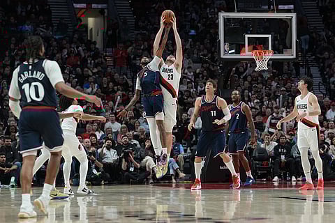 Portland Trail Blazers center Donovan Clingan (23) and Los Angeles Clippers forward Derrick Jones Jr. (5) reach for the ball during the second half of an NBA basketball game in Portland, Ore.