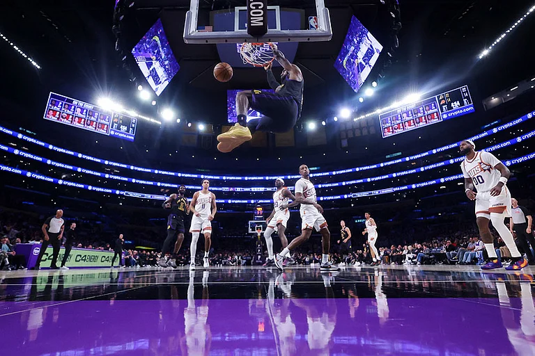 Los Angeles Lakers forward LeBron James dunks as additional players watch against the Phoenix Suns during the second half of an NBA basketball game in Los Angeles. - | Photo: AP/Jessie Alcheh