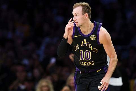 Los Angeles Lakers guard Luke Kennard gestures after making a 3-point basket against the Phoenix Suns during the first half of an NBA basketball game in Los Angeles.