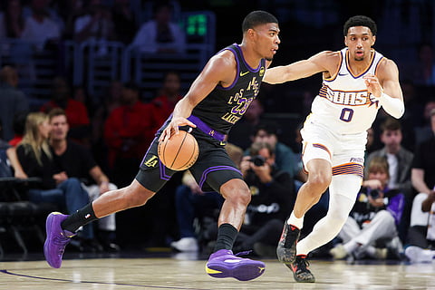 Los Angeles Lakers forward Rui Hachimura, left, dribbles against Phoenix Suns forward Ryan Dunn (0) during the first half of an NBA basketball game in Los Angeles.