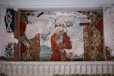 A view of a damaged painting of a woman is on the wall of a historic site in Isfahan, Iran.