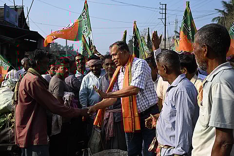 BJP candidate for Santipur constituency, Swapan Kumar Das, centre, greets people during an election campaign ahead of the West Bengal Assembly Election, in Nadia district.