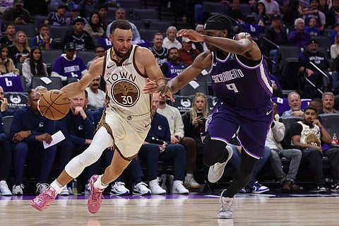 Golden State Warriors guard Stephen Curry (30) dribbles the ball past Sacramento Kings forward Precious Achiuwa (9) during the second half of an NBA basketball game against the Sacramento Kings in Sacramento, Calif.