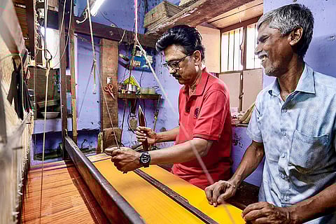 In this image posted on April 12, 2026, Tamil Nadu Chief Minister MK Stalin uses a handloom during an early morning outreach campaign ahead of the state Assembly elections, in Ramanathapuram, Tamil Nadu.