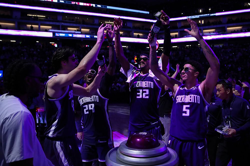 Sacramento Kings center Maxime Raynaud (42), Daeqwon Plowden (29), Dylan Cardwell (32) and Nique Clifford (5) light the beam after the Kings victory over the Golden State Warriors in an NBA basketball game  in Sacramento, Calif. - | Photo: AP/Scott Marshall