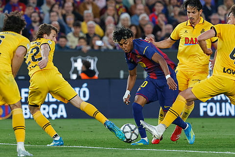Barcelona's Lamine Yamal, centre, and Espanyol's Carlos Romero, centre left, challenge for the ball during the Spanish La Liga soccer match between Barcelona and Espanyol in Barcelona, Spain.