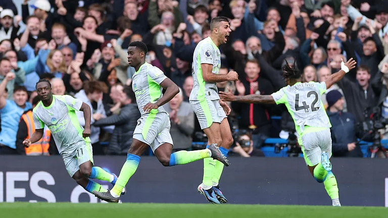 Manchester City's Marc Guehi, left, and Jeremy Doku celebrate after scoring during the Premier League soccer match between Chelsea and Manchester City in London, Sunday, April 12, 2026. - | Photo: AP/Ian Walton