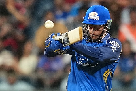 Mumbai Indians' Mitchell Santner plays a shot during the Indian Premier League cricket match between Mumbai Indians and Royal Challengers Bengaluru, in Mumbai, India.