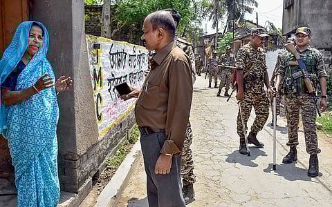 Officials and security personnel interact with a resident during an area visit to assess preparedness and ensure a peaceful and smooth polling process ahead of the Legislative Assembly elections, in Murshidabad district, West Bengal.