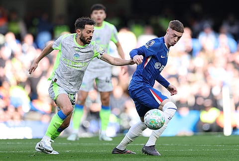 Manchester City's Bernardo Silva, left, and Chelsea's Cole Palmer fight for the ball during the Premier League soccer match between Chelsea and Manchester City in London.
