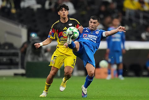 Cruz Azul's Erik Lira, right, controls the ball challenged by America's Kevin Alvarez during a Mexican soccer league match in Mexico City.