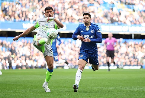 Manchester City's Matheus Nunes clears the ball in front of Chelsea's Pedro Neto during the Premier League soccer match between Chelsea and Manchester City in London.