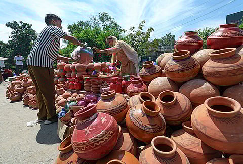 A vendor sells earthen pots on the eve of Baisakhi, in Jammu.