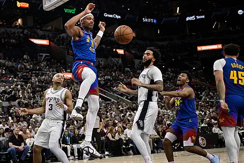 Denver Nuggets guard Bruce Brown (11) dunks against San Antonio Spurs forward Julian Champagnie (30) during the second half of an NBA basketball game in San Antonio.