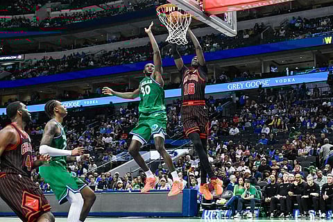 Chicago Bulls' Mouhamadou Gueye dunks over Dallas Mavericks' Moussa Cisse during an NBA basketball game in Dallas.