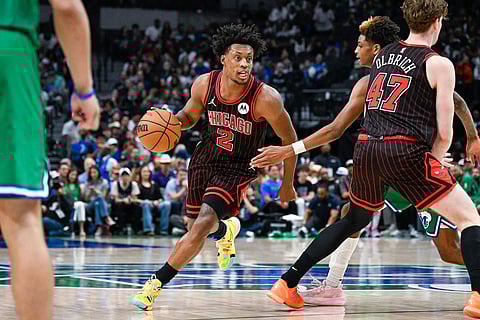 Chicago Bulls' Collin Sexton drives around Dallas Mavericks' AJ Johnson as he's blocked by Chicago Bulls' Lachlan Olbrich during an NBA basketball game in Dallas.