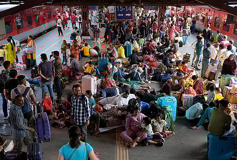 Large crowds occupy the New Delhi Railway Station platform, as passengers sit, rest, and wait amid a heavy rush of many going back to their native states due to the LPG crisis. 