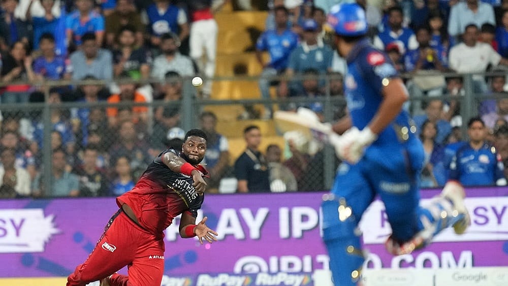 Royal Challengers Bengaluru's Romario Shepherd throws a ball during the Indian Premier League cricket match between Mumbai Indians and Royal Challengers Bengaluru, in Mumbai , India. - | Photo: AP/Rafiq Maqbool