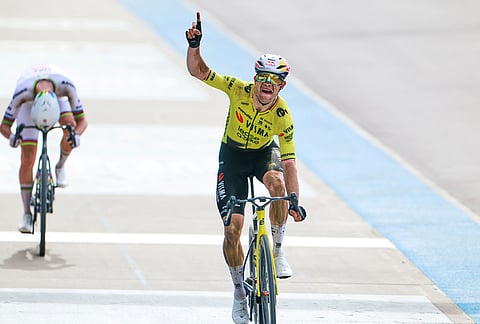 Belgium's Wout van Aert crosses the finish line ahead of Tadej Pogacar of Slovenia, left, to win the Paris-Roubaix cycling race in Roubaix, France.
