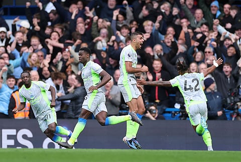 Manchester City's Marc Guehi, left, and Jeremy Doku celebrate after scoring during the Premier League soccer match between Chelsea and Manchester City in London.