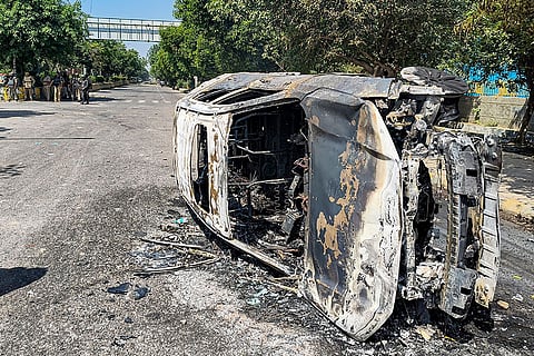 Wreckage of a car is seen after it was burnt during a protest by factory workers demanding a hike in wages, in Noida, Gautam Buddh Nagar district, Uttar Pradesh.