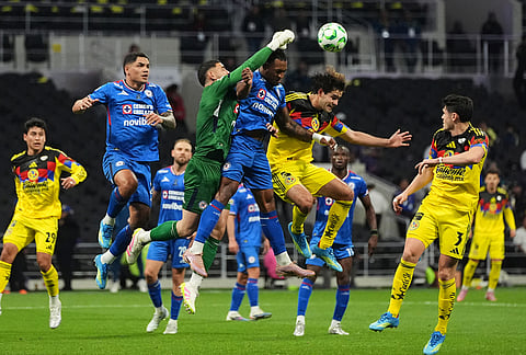 Cruz Azul's goalkeeper Andres Gudino, third from left, clears the ball during a Mexican soccer league match against America in Mexico City.