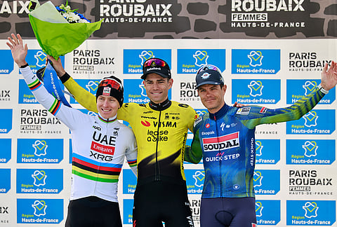 Belgium's Wout van Aert, center, celebrates on the podium after winning the Paris-Roubaix cycling race ahead of second placed Tadej Pogacar of Slovenia, left, and third placed Jasper Stuyven of Belgium, right, in Roubaix, France.