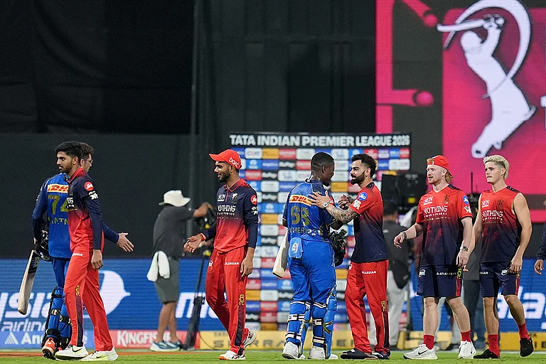Royal Challengers Bengaluru's players being congratulated by Mumbai Indians' Sherfane Rutherford and Mitchel Santner after winning the Indian Premier League (IPL) 2026 T20 cricket match, in Mumbai, Maharashtra. - | Photo: PTI/Kunal Patil