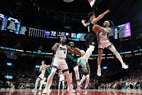 Sacramento Kings guard Devin Carter (22) tries to pass the ball around Portland Trail Blazers forward Deni Avdija (8) during the second half of an NBA basketball game in Portland, Ore.