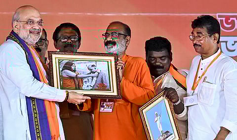 Union Home Minister Amit Shah, left, being felicitated during a public meeting in support of BJP candidates ahead of the West Bengal Assembly elections, in Malda.