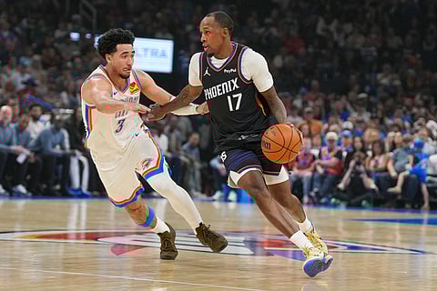 Phoenix Suns guard Jamaree Bouyea (17) pushes past Oklahoma City Thunder guard Jared McCain (3) during the first half of an NBA basketball game in Oklahoma City.