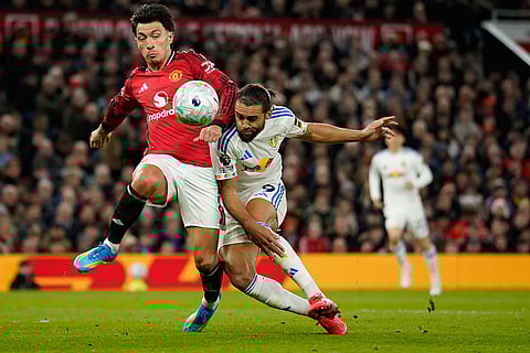 Manchester United's Lisandro Martinez, left, and Leeds' Dominic Calvert-Lewin fight for the ball during the Premiier League soccer match between Manchester United and Leeds in Manchester, England.