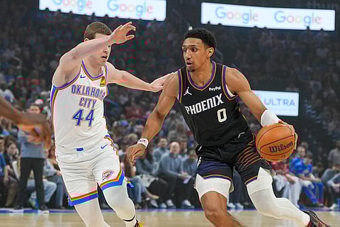 Phoenix Suns forward Ryan Dunn (0) drives past Oklahoma City Thunder guard Nikola Topic (44) during the first half of an NBA basketball game in Oklahoma City.
