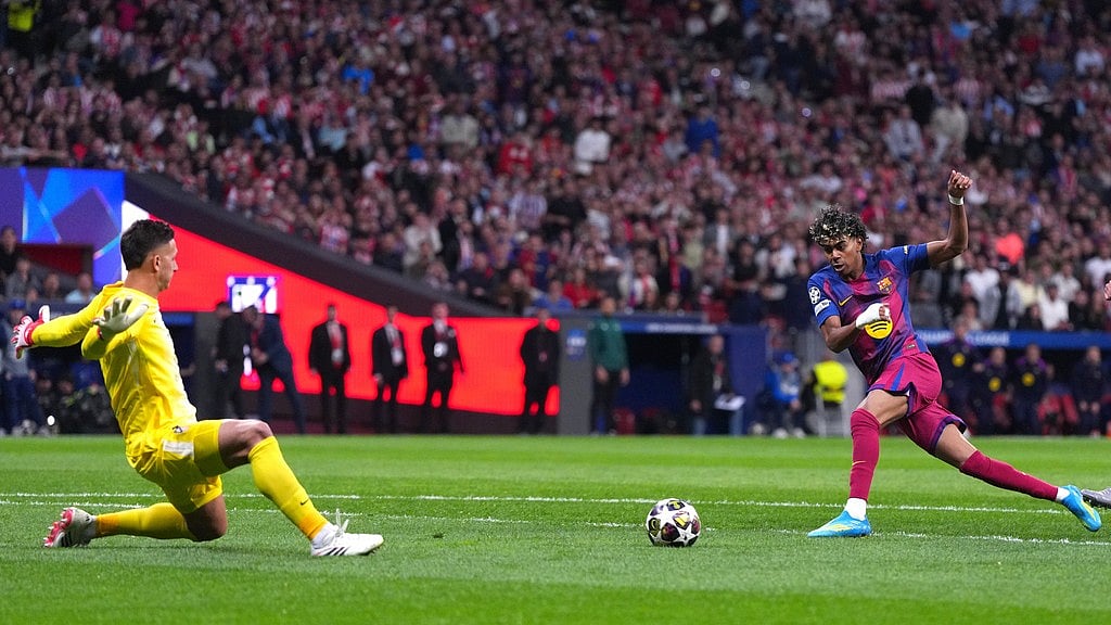 Barcelona's Lamine Yamal, right, scores the opening goal during the Champions League quarterfinal second leg soccer match between Atletico Madrid and Barcelona in Madrid, Spain, Tuesday, April 14, 2026. - AP Photo/Manu Fernandez