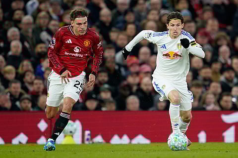 Manchester United's Manuel Ugarte, left, and Leeds' Brenden Aaronso[ run for the ball during the Premiier League soccer match between Manchester United and Leeds in Manchester, England.